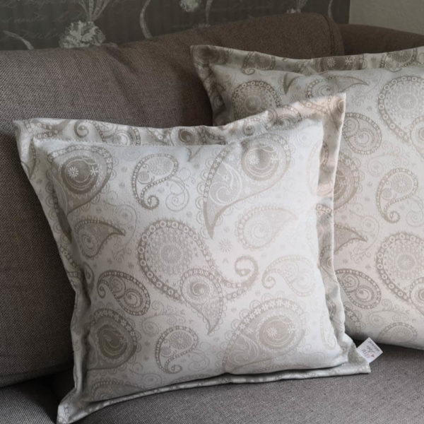 Jacquard Kissenhülle Creme mit beigen Ornamenten auf der Couch