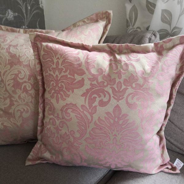 Jacquard Kissenhülle Rosa mit beigen Ornamenten auf dem Sofa